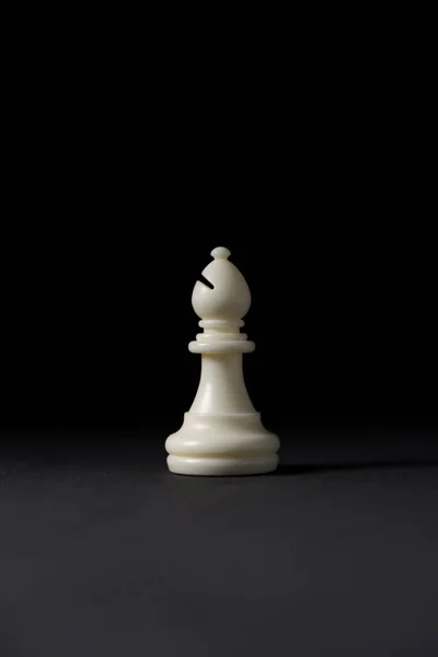 Siyah arkaplanda beyaz fil satranç taşı