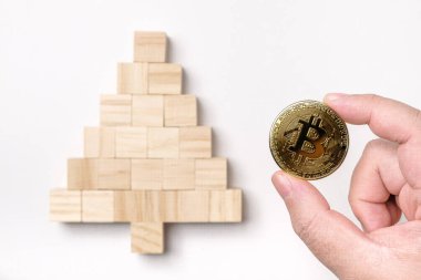 Beyaz arka planda izole edilmiş bir Noel ağacına yerleştirilen tahta kübün üzerine bitcoin koymak, Noel konsepti, mutlu yıllar, bitcoin, kripto para