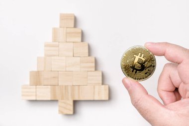 Beyaz arka planda izole edilmiş bir Noel ağacına yerleştirilen tahta kübün üzerine bitcoin koymak, Noel konsepti, mutlu yıllar, bitcoin, kripto para