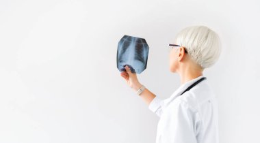 Doktor göğüs radyografı akciğer hastanesinin röntgen filmini inceliyor. Hastalıkları kontrol ve izleme, solunum organları. Pulmonoloji konsepti. Metin için boş alanı kopyala.