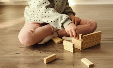 Küçük çocuk masa oyunu oynuyor, çocuk tahta tuğla bloklarından inşa ediyor. Çocuk Eğitim Oyunları Konsepti. 