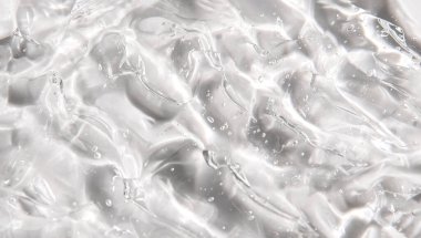 Beyaz arka planda şeffaf serum jeli sürüyorum. Hyaluronik asit ve kozmetik arka plan. Nemlendirici doku kavramı.
