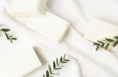 Doğal el yapımı beyaz sabun ya da banyo havlusundaki organik spa çubukları. Düz yatış, üst görünüm.