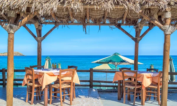 Café de playa con mesas y sillas de madera en el mar —  Fotos de Stock