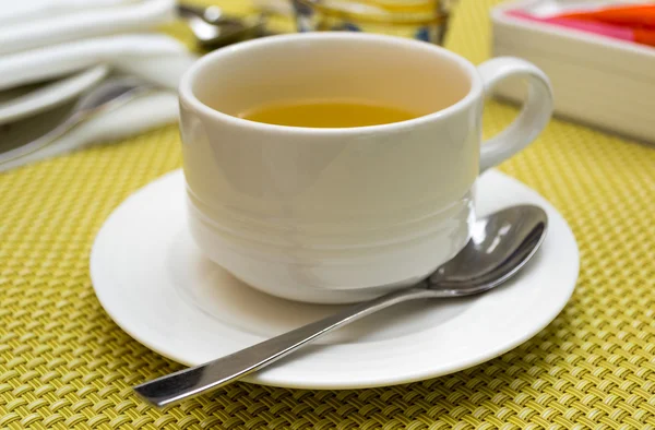 Taza de té en platillo con una cuchara — Foto de Stock