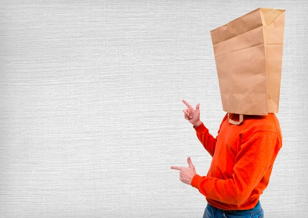 Señalando al hombre en bolsa de papel ecológica en la cabeza —  Fotos de Stock