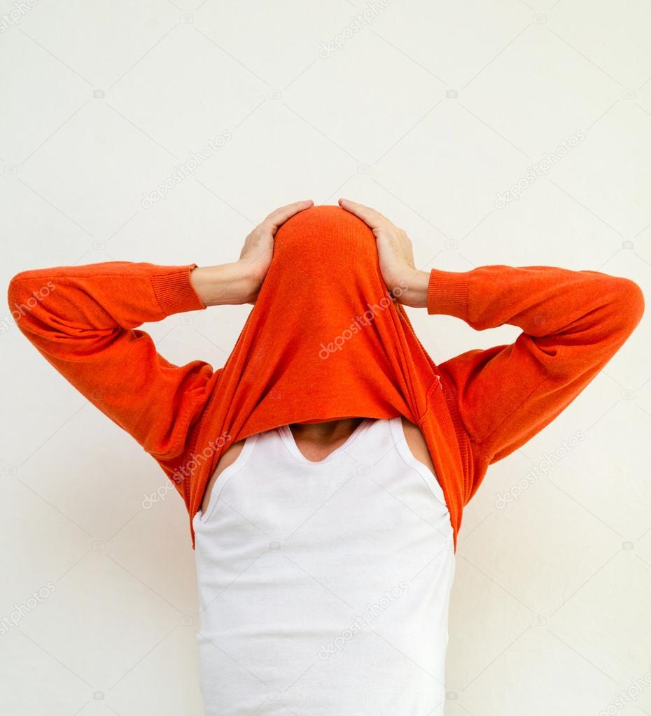 Funny portrait of man in sweater on head against white wall