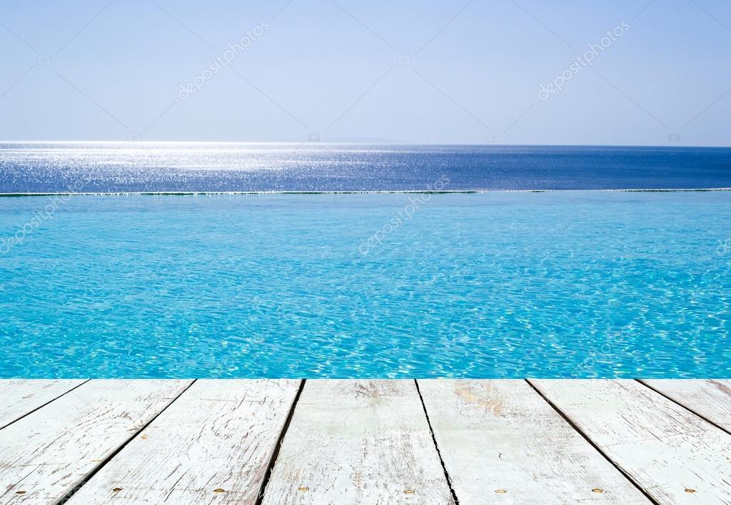 Infinity swimming pool  and empty wooden plank