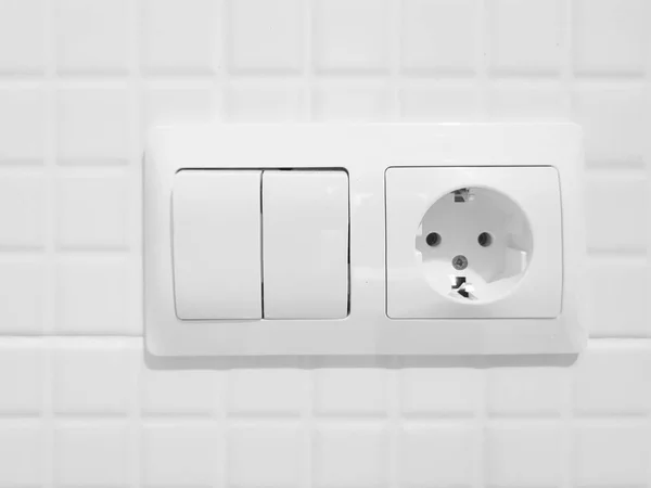 New white switch and socket on a tiled wall — Stock Photo, Image