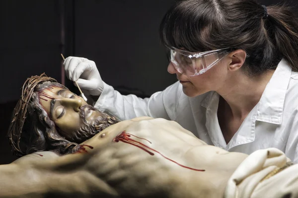 Cleaning of the face of a wooden sculpture of Christ crucified — Stock Photo, Image