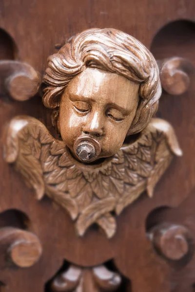 Cherub with suck on wood carving — Stock Photo, Image