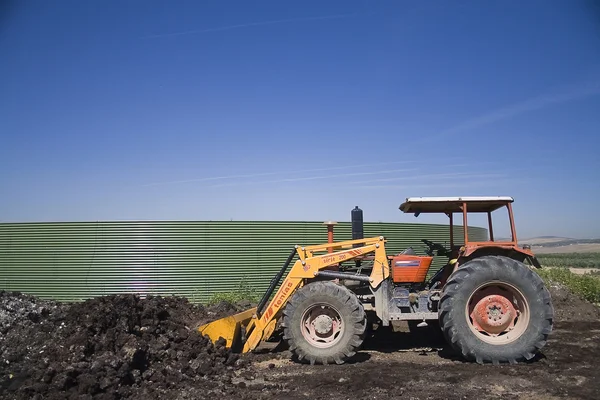 Traktor v vor alpechin sběr kompostu poblíž jaen — Stock fotografie