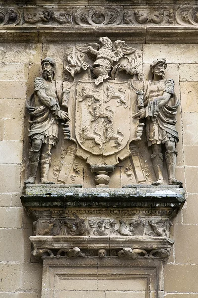 Escudo de piedra enmarcado por dos hombres, relieve de la fachada de la capilla de El Salvador de Ubeda — Foto de Stock