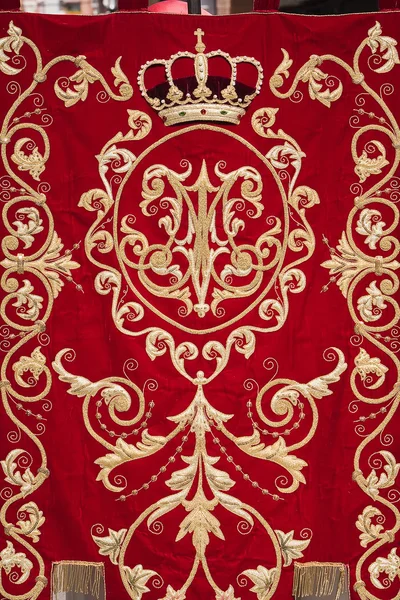 Embroidery thread of gold on red velvet — Stock Photo, Image