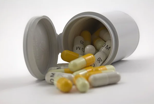 黄色と白の錠剤を白い背景で隔離のプラスチック ボートの内容 — ストック写真