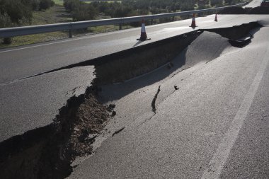 Asphalt road with a crack caused by landslides clipart