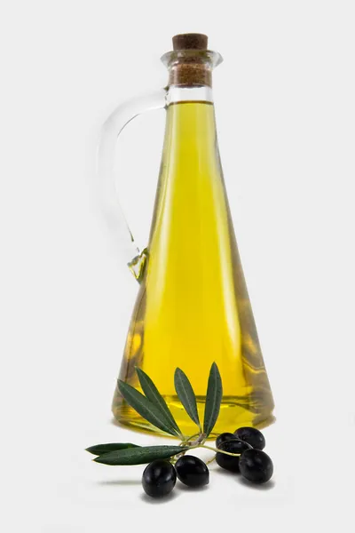 Branch with olives and a bottle of olive oil isolated on white — Stock Photo, Image