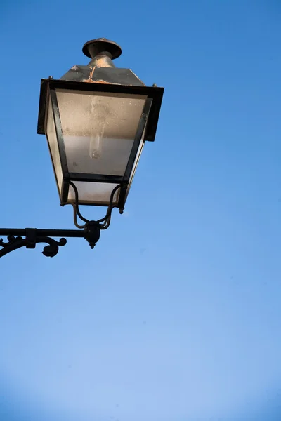 A wrought iron lamp on a weathered wall in Spain