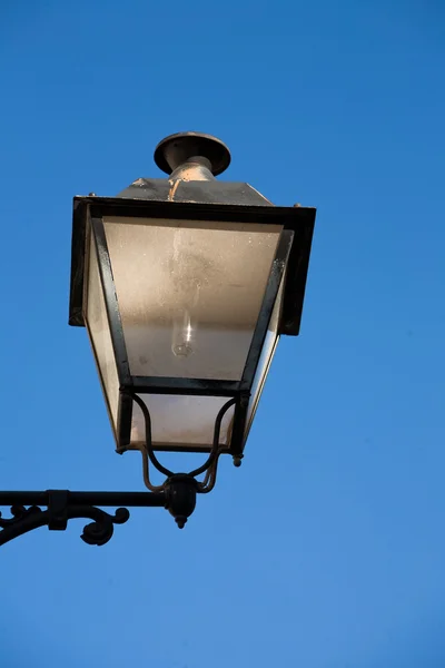 A wrought iron lamp on a weathered wall in Spain — Stock Photo, Image