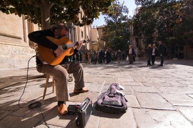 kapı sagrario Kilisesi'nin yanındaki bir ağacın altında gitarist