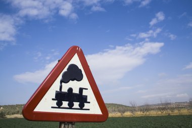 Warning sign worn of level crossing without barriers, blue sky with clouds clipart