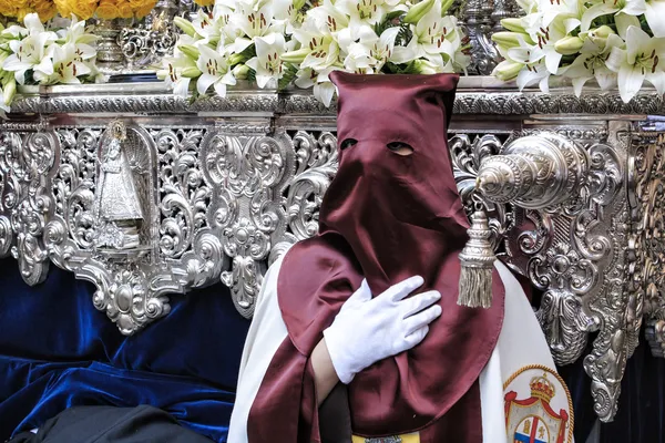 Nazarene, die mit der Hand auf der manigueta den Thron in einer Prozession der heiligen Woche geht — Stockfoto