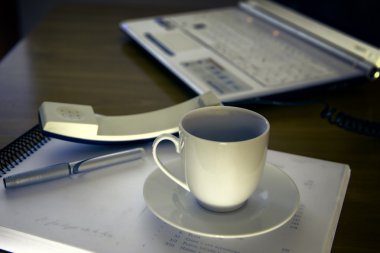 Ofis Büro bir fincan kahve bilgisayar laptop, defter, kalem ile çalışmak