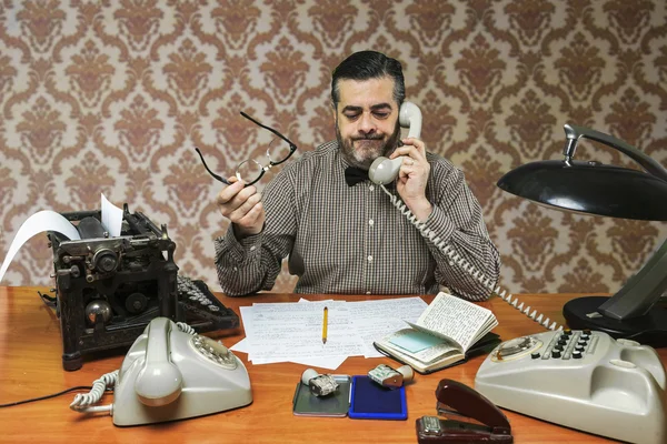 Empleado con gafas hablando por teléfono en la oficina en la década de 1960 — Foto de Stock