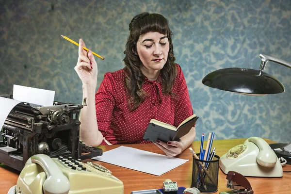 Secretaris in het kantoor met een potlood in de hand kijkt naar zijn notitieboekje, 1960 's scène — Stockfoto