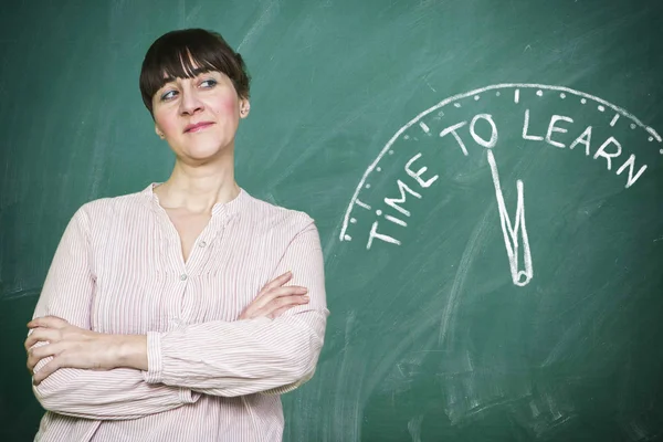 Woman smiles writes on a blackboard to learn concept — Stock Photo, Image