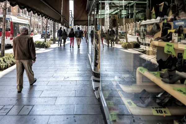 通りと古い靴ショップ ラ cordobesa、グラナダ、スペインの飾り窓に反映を介してグランを歩く人 — ストック写真