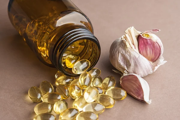 Капсулы чесночного масла, витамины D таблетки — стоковое фото