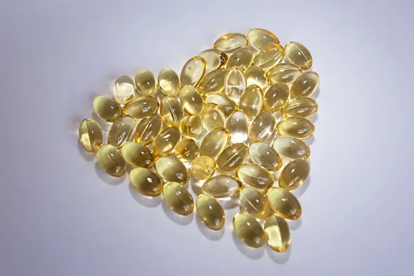 Tőkehal máj olaj omega-3 gel kapszula formájában a szív elszigetelt — Stock Fotó