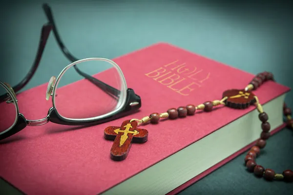 Gafas ajustadas en la sagrada Biblia y cuentas — Foto de Stock