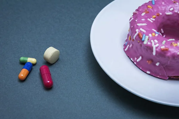 Различные лекарства для борьбы с диабетом вместе со сладким тортом — стоковое фото