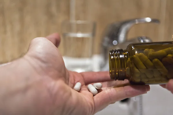 Pillole versate a mano per il dolore di una bottiglia in bagno — Foto Stock