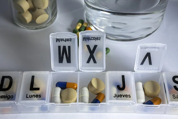 Pills with pill organizer, writing in Spanish — Stock Photo, Image