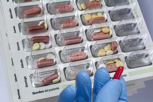 Comprimidos com organizador de pílulas, escrevendo em espanhol — Fotografia de Stock