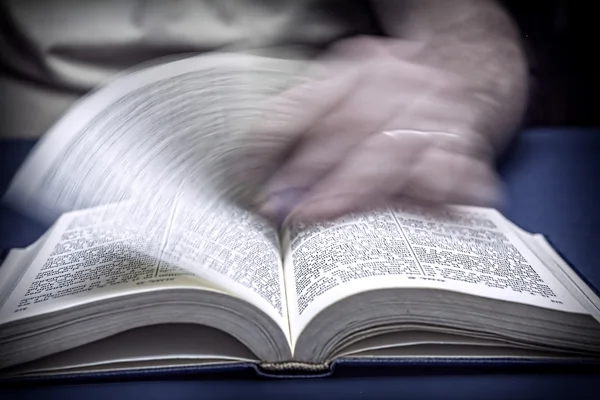 Mann blättert in einer alten kleinen Bibel oder einem Buch — Stockfoto