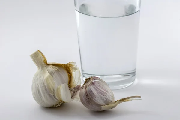 Glass of water and some garlic isolated on white background — Stock Photo, Image