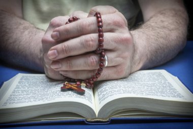 Christian believer praying to God with rosary in hand clipart