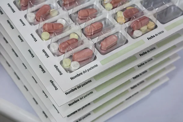 Comprimidos com organizador de pílulas, escrevendo em espanhol — Fotografia de Stock