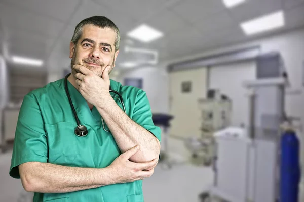 Smiling doctor with arms crossed in operating room — Stock Photo, Image