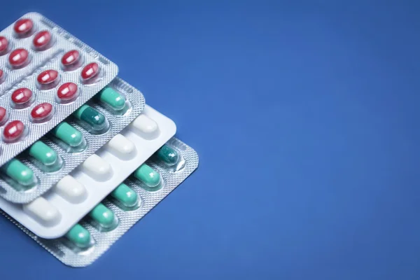 Some pills aligned isolated on blue background — Stock Photo, Image