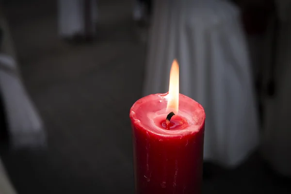Красная свеча горит оранжевым пламенем в темноте — стоковое фото