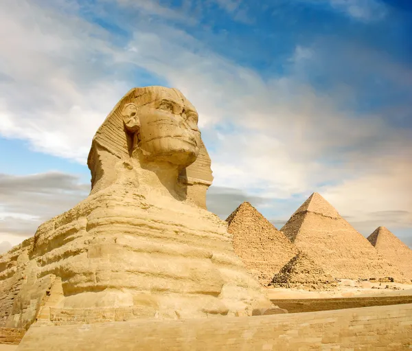 Esfinge famosa y las grandes pirámides bajo interesantes nubes de la tarde, El Cairo, Egipto —  Fotos de Stock