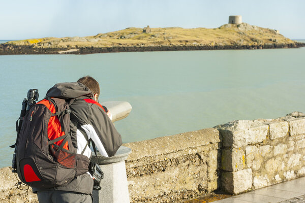 Man looking to Dalkey island by binoculars