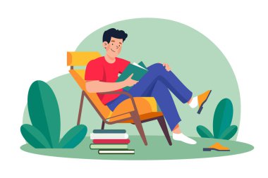 Young man sits in an armchair and reads a book