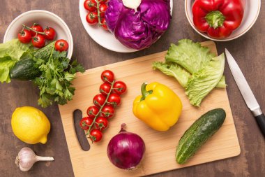 Mutfaktaki tahta tahtada sağlıklı diyet yemekleri pişirmek için farklı sebzeler. Vejetaryen vejetaryen yemeği pişirmek.