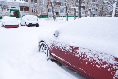 Şiddetli kar yağışı sonrası araçlar, apartman binasının avlusunda kış kasabası caddesinde park halinde.